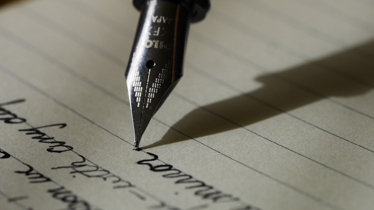 A notebook with pen on a desk, representing the fundamentals of the writing craft
