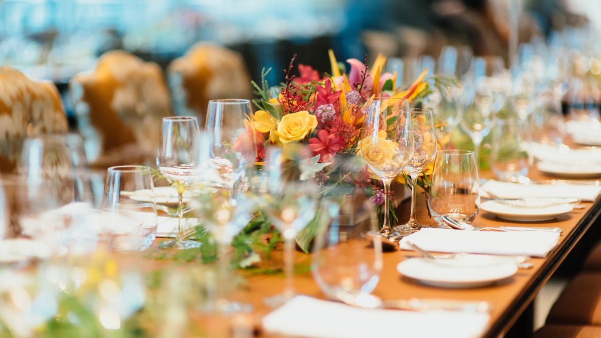 An elegantly set event dinner table with florals and candles