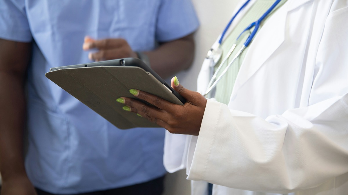 A doctor showing a patient information on a tablet