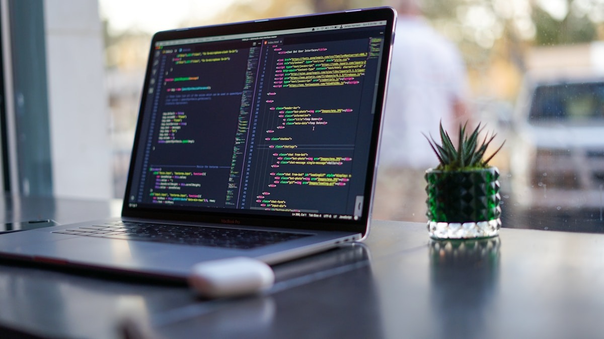 Developer working with AI coding assistant on multiple screens showing code
