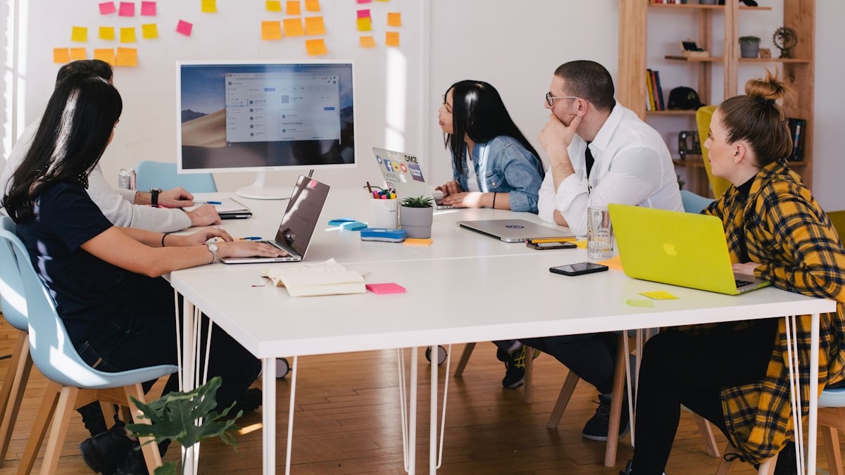 Two professionals reviewing documents and discussing AI tool decisions at a conference table