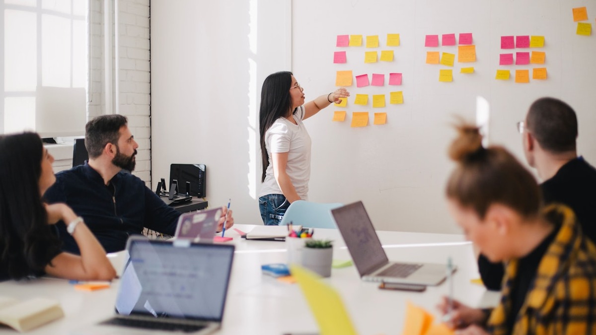 A team organizing colorful sticky notes on a wall during a brainstorming session