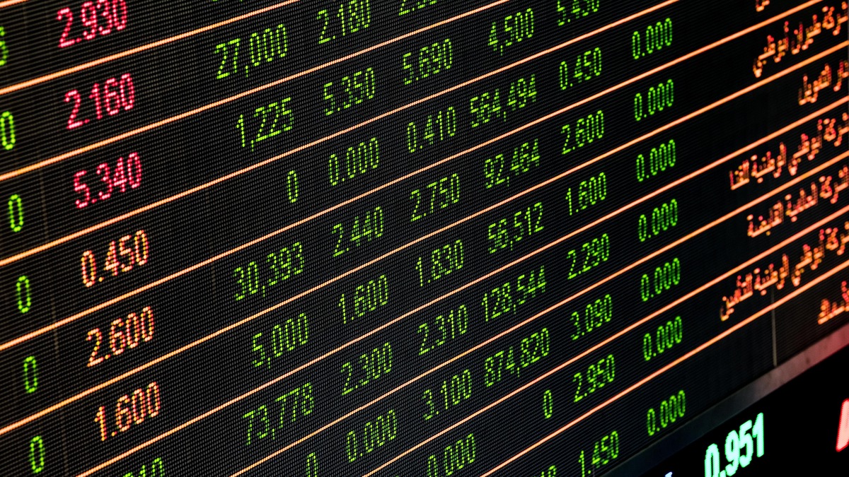 Close-up of a financial stock ticker board displaying green and red numbers