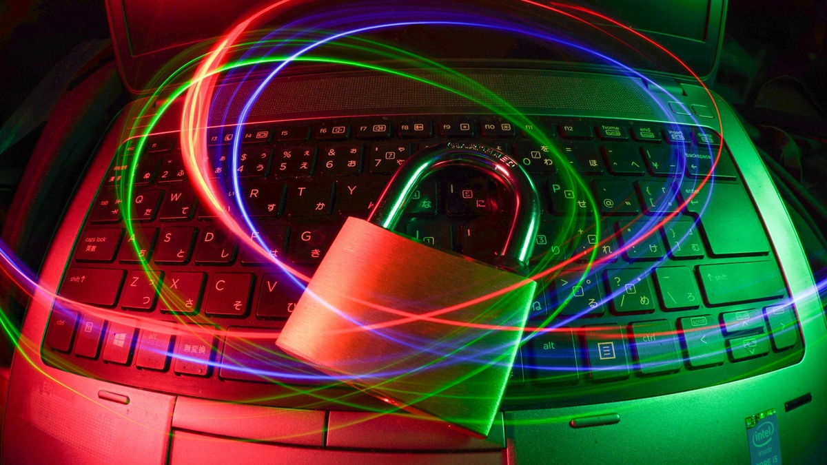 Glowing padlock on a keyboard surrounded by coloured light trails