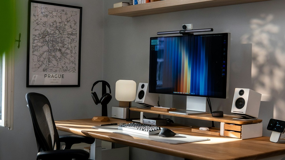 A modern desk setup with a computer displaying code and data on multiple monitors