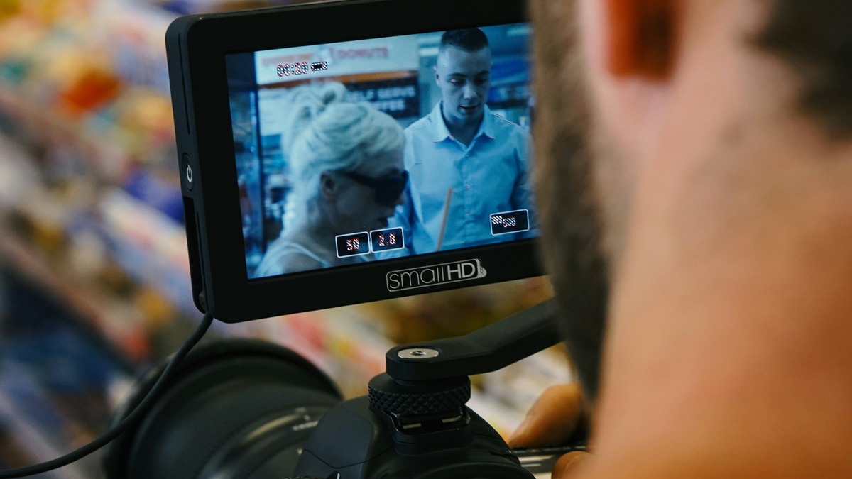 Person holding a professional video camera while filming outdoors