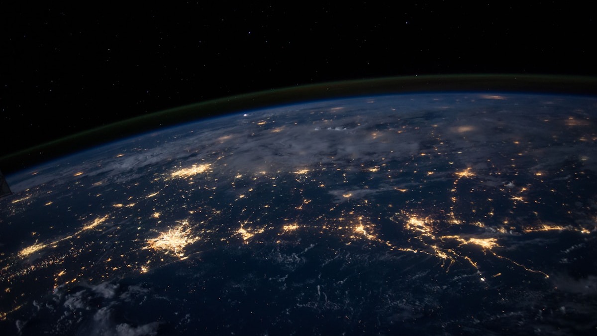Earth from space at night showing city lights across multiple continents