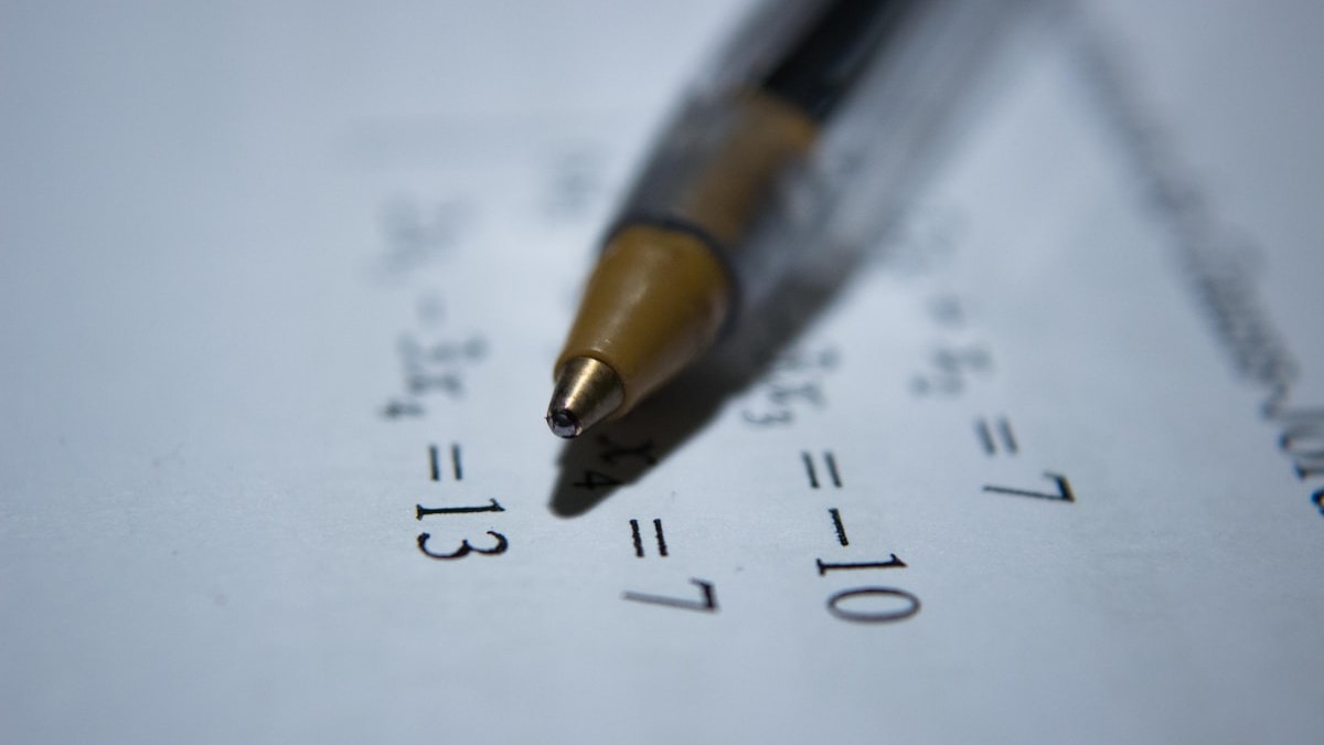 A pen resting on mathematical calculations on paper