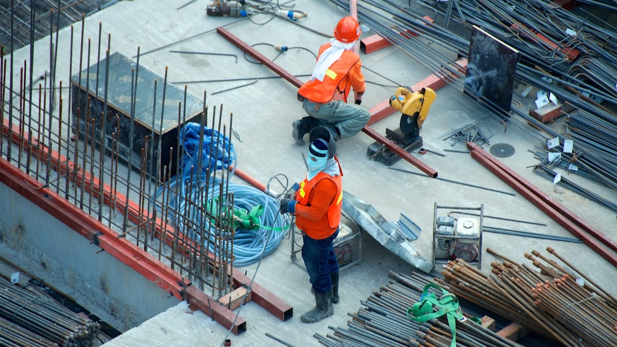 Construction workers in high-visibility vests on an active building site