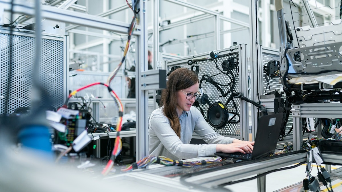 A person walking through a warehouse while an autonomous robot navigates alongside them, representing the navigation capabilities Qwen-RobotNav is designed to provide