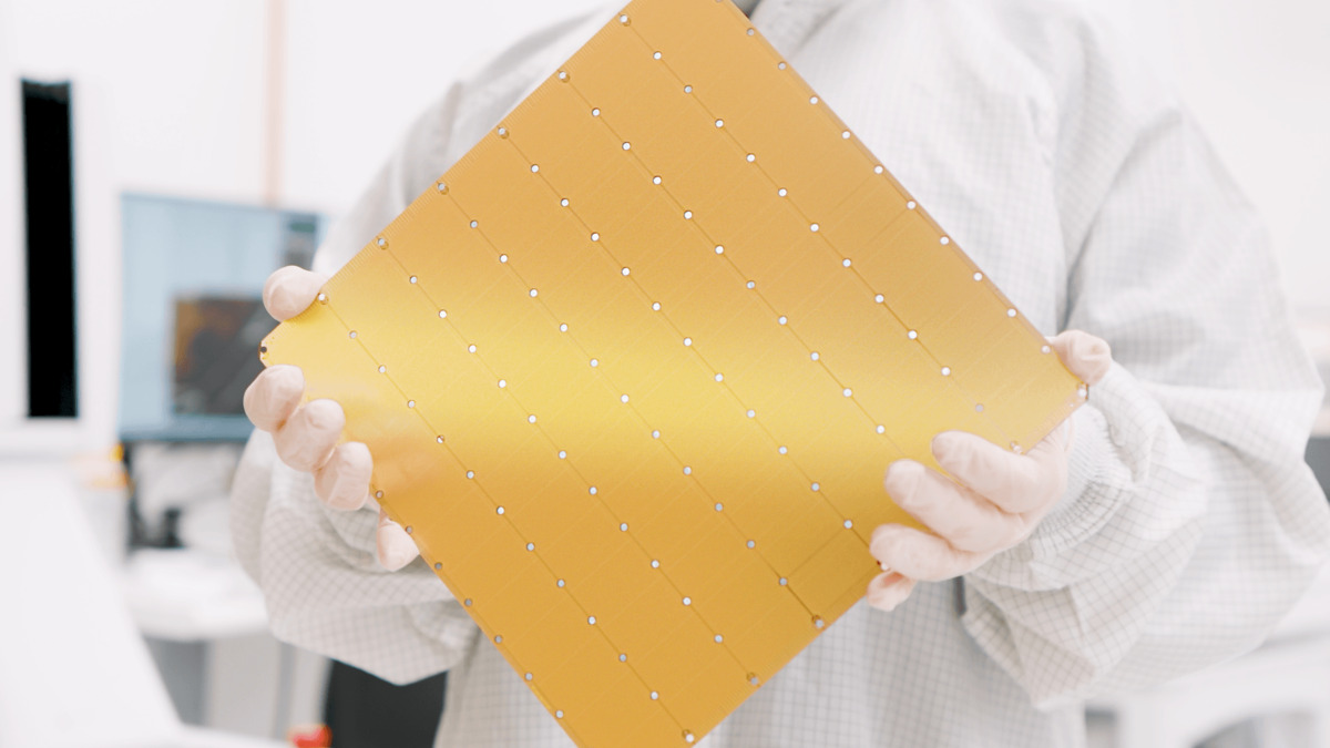 The Cerebras WSE-3 chip - a full wafer-scale processor held by a cleanroom-suited engineer