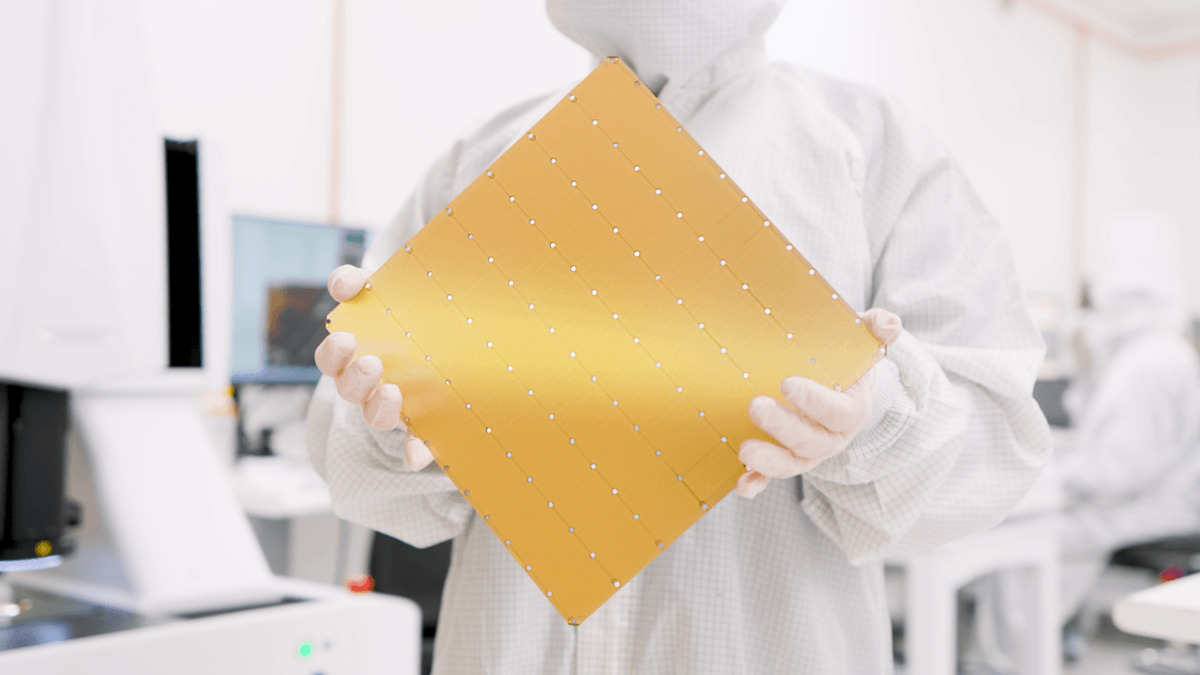 A technician in cleanroom gear holds the Cerebras WSE-3 wafer-scale chip