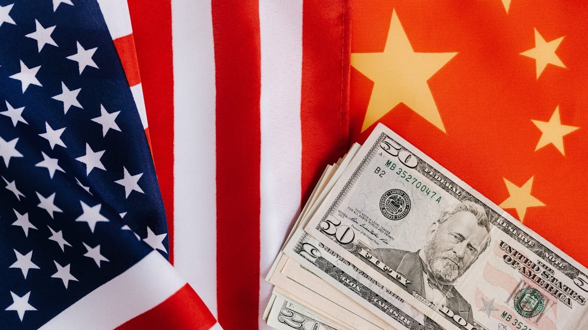 US and Chinese flags alongside dollar bills