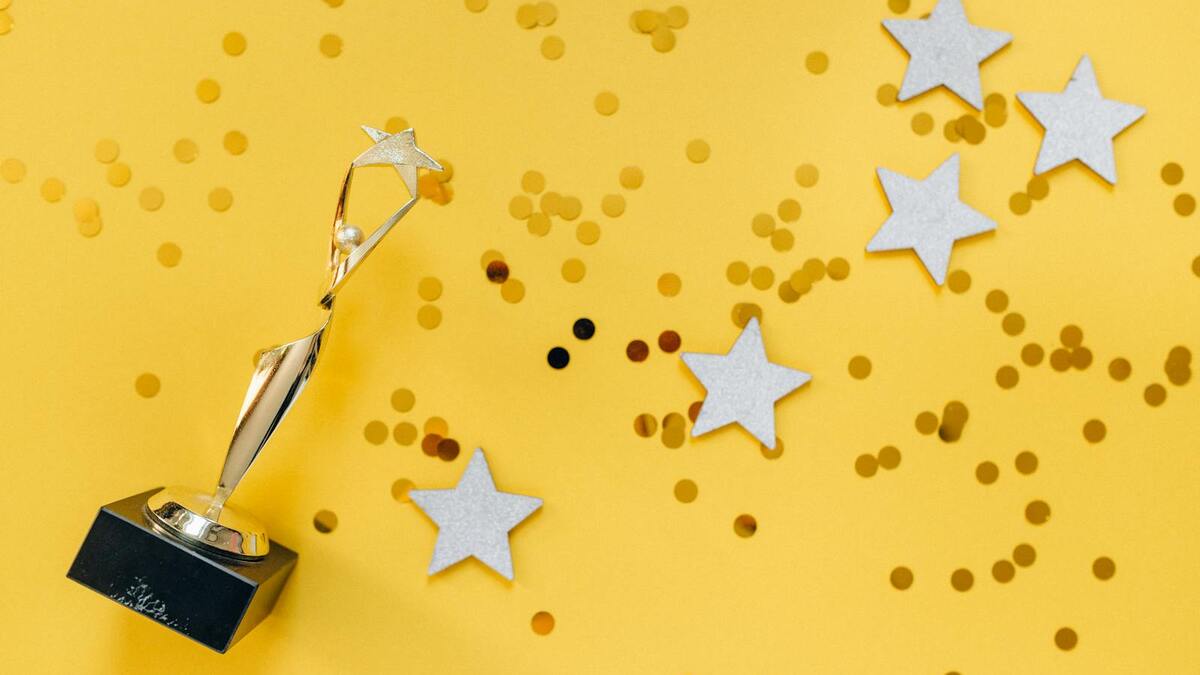 Golden award statuette with star confetti