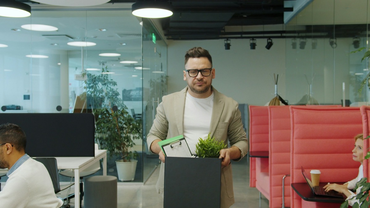 Workers packing up personal items from an office desk