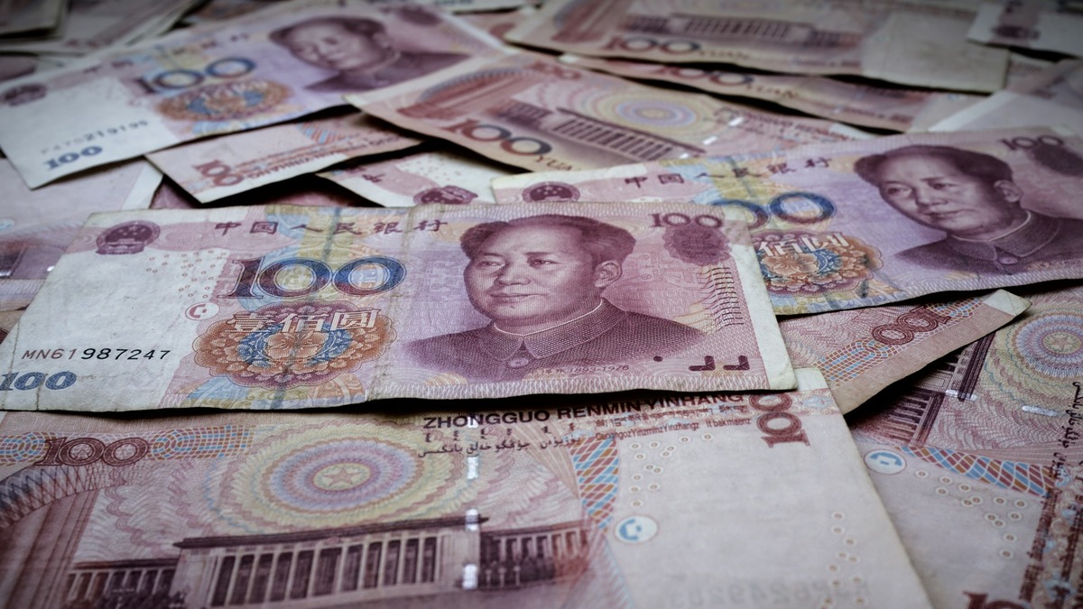 Stacks of 100 yuan banknotes spread across a table