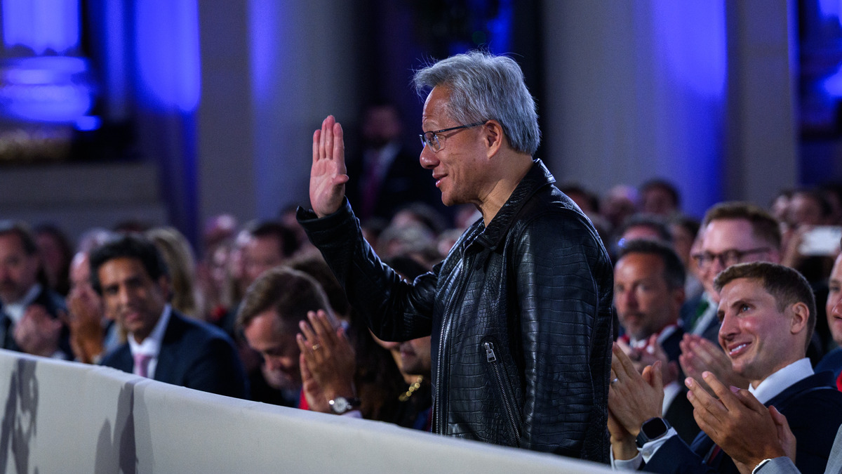 Nvidia CEO Jensen Huang waves to applause at a public event