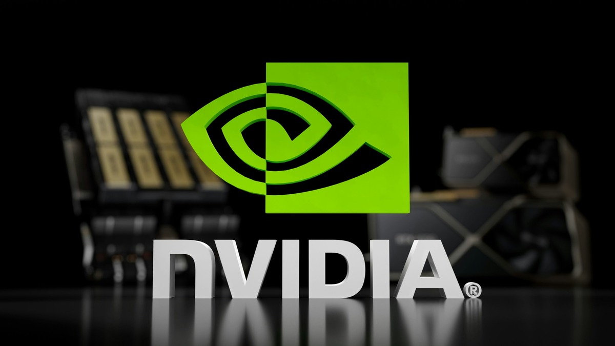 A 3D Nvidia logo displayed on a table with GPU hardware blurred in the background