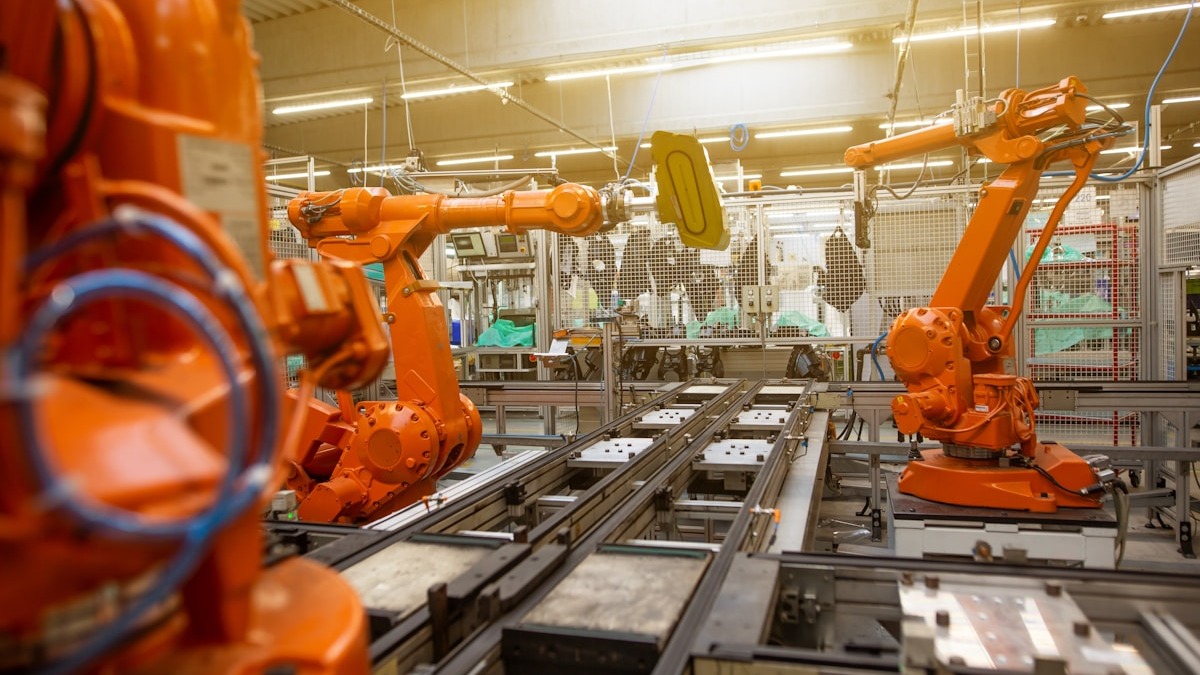 Industrial robots on a manufacturing floor with precise automated arm movements