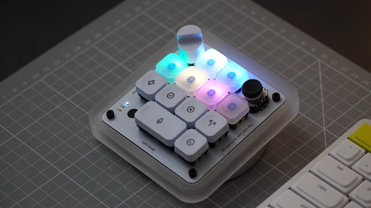 The Codex Micro keypad lit up with RGB Agent Keys and its joystick, on a desk next to a standard keyboard