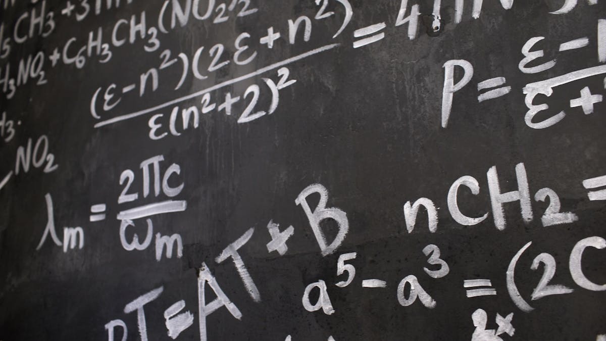 Close-up of complex equations written on a blackboard