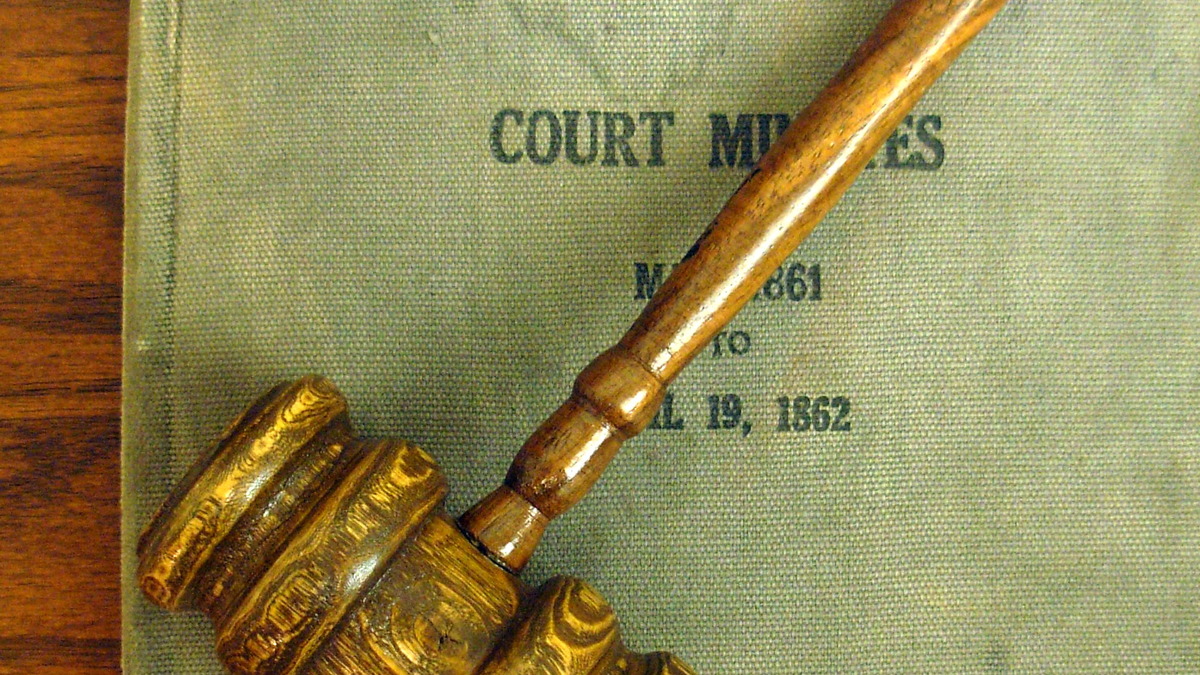 A wooden court gavel resting on a surface