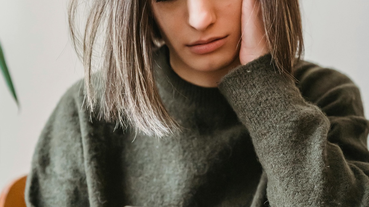 A woman looking at her smartphone with a concerned expression
