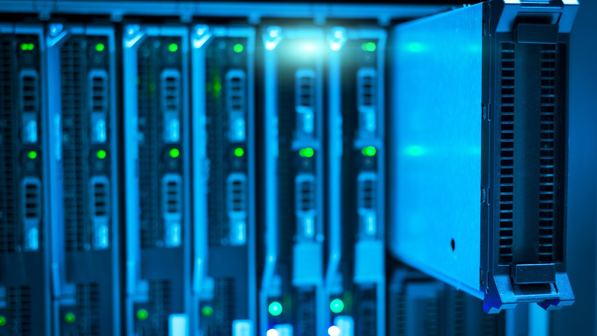 Rows of enterprise server racks with illuminated status indicators in a data center aisle