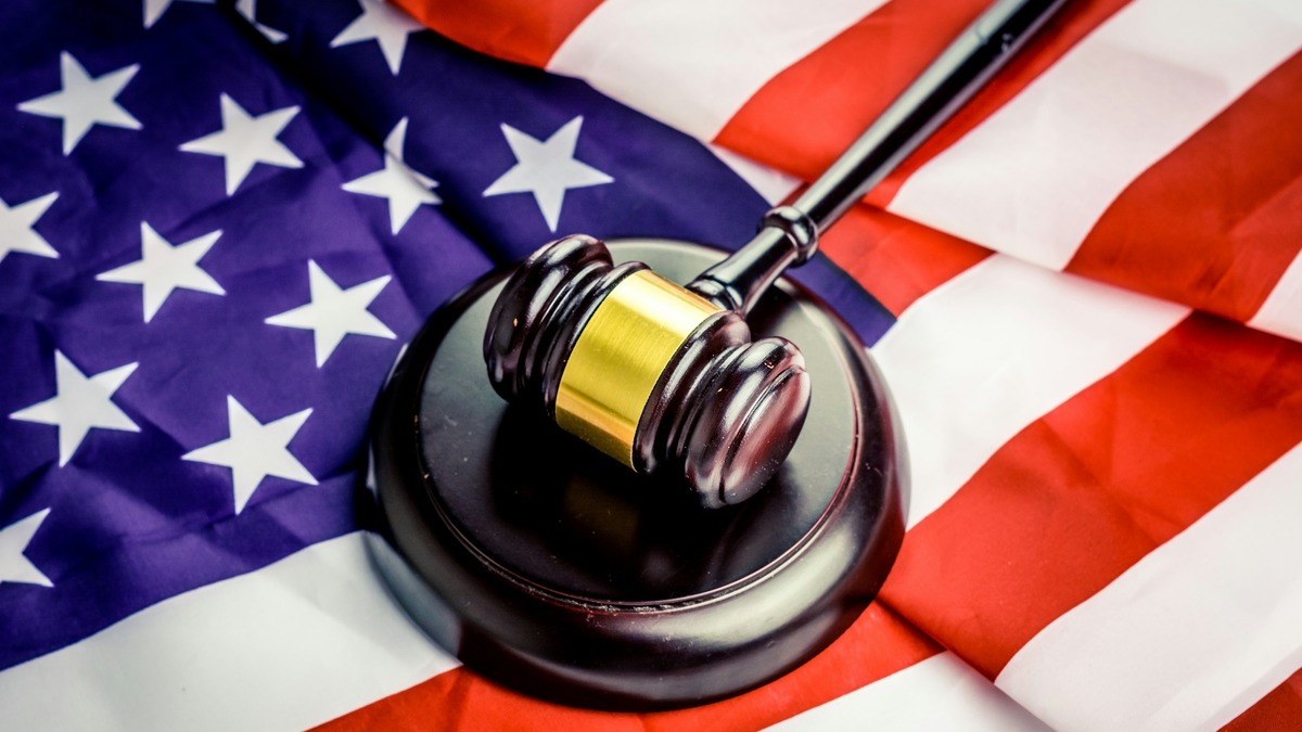 A judge's gavel resting on top of an American flag