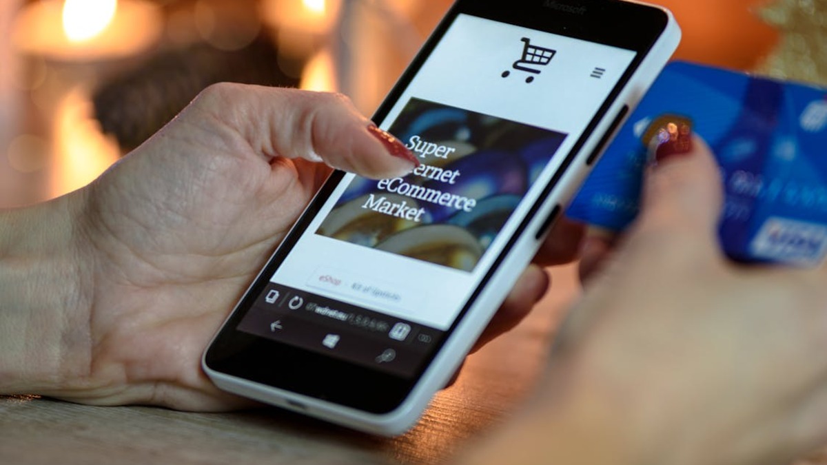 A person browsing an e-commerce site while holding a payment card