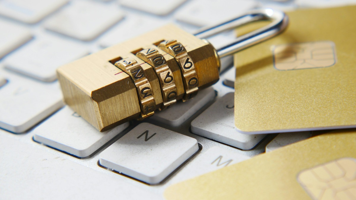 A golden padlock resting on top of a computer keyboard