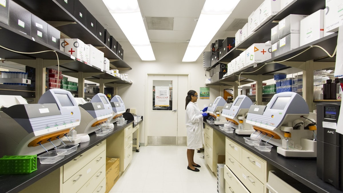 A researcher in a genomics lab working with sequencing equipment