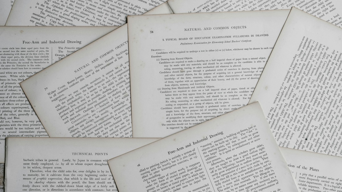 Stacked academic research papers and notebooks on a desk