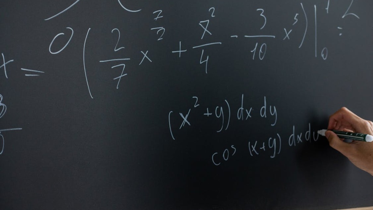 Mathematical equations written on a blackboard in chalk