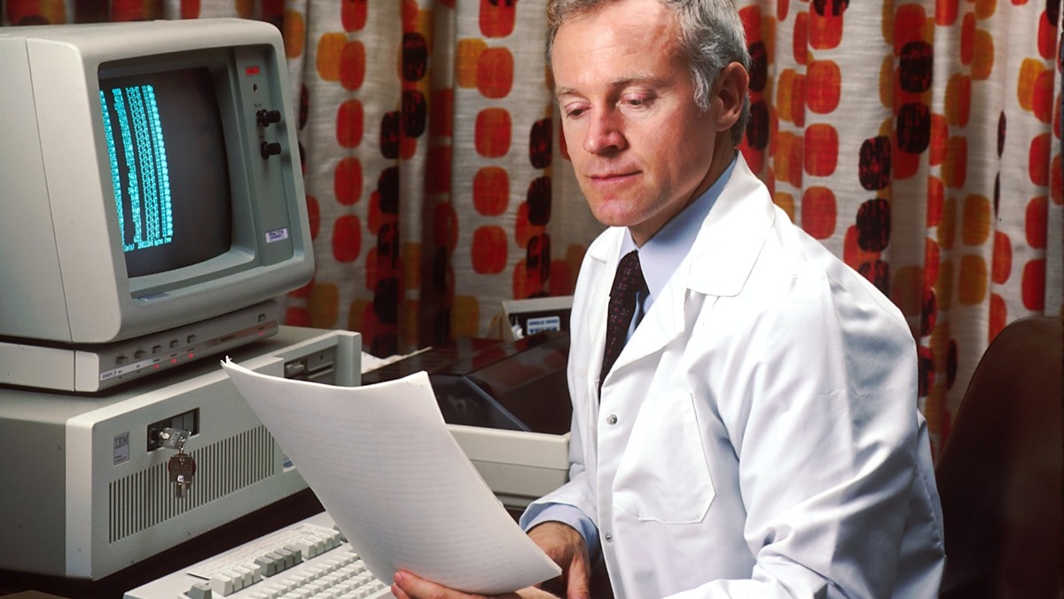 A researcher reviews data at a computer workstation