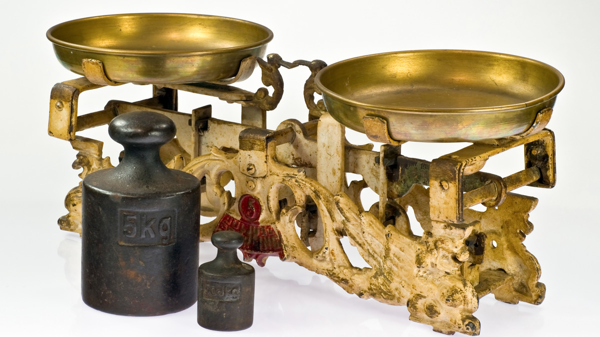 A traditional two-pan balance scale on a white background