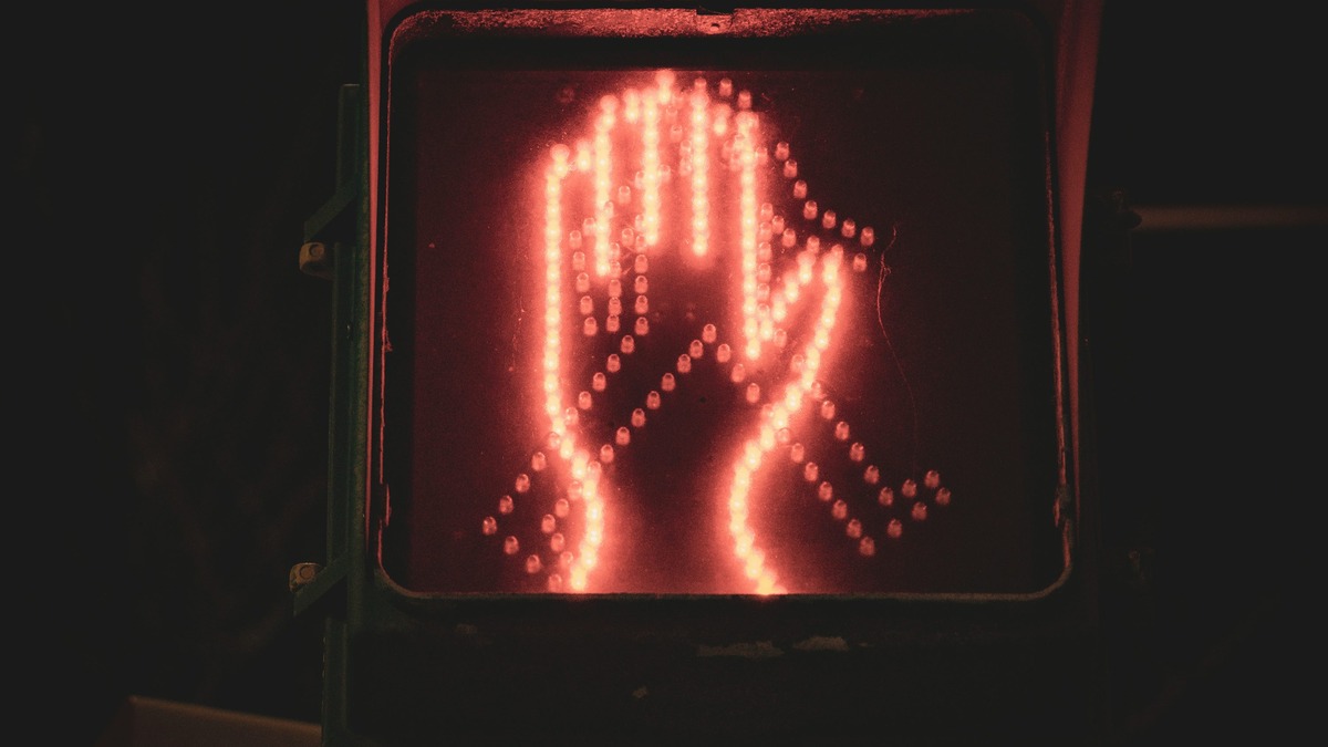 A red pedestrian stop signal glowing in the dark