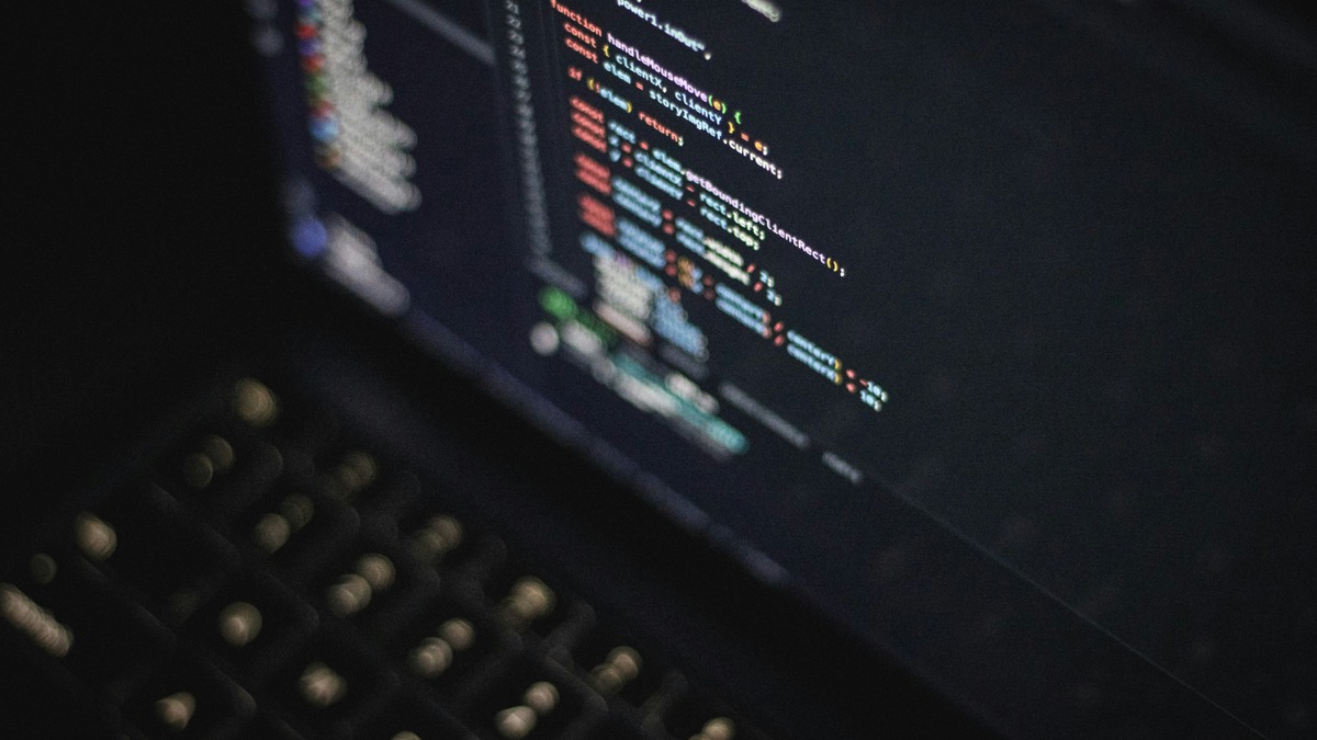 Colorful code on a laptop screen in a dark developer environment