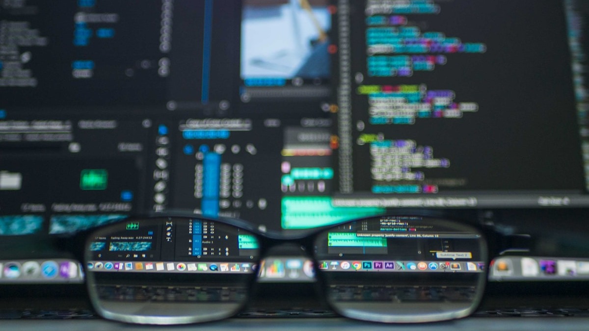 A cybersecurity professional working at a command-line terminal running network security tests in a dimly lit room with multiple monitors