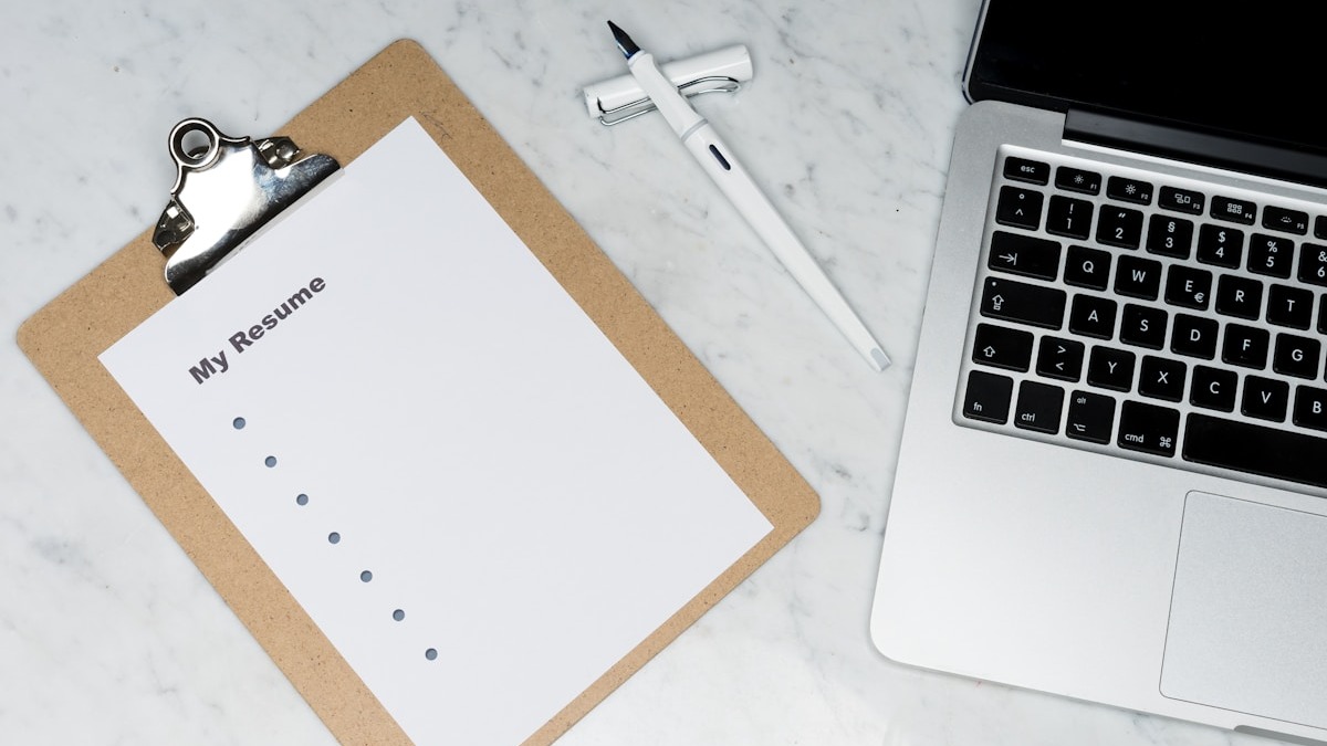 An open notebook with handwritten notes alongside a laptop showing digital notes