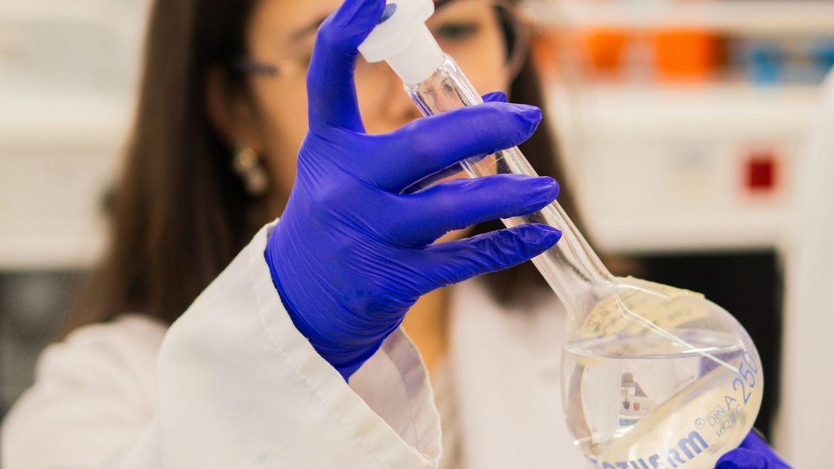 Scientist handling laboratory equipment - the precision and reproducibility of synthetic data generation mirrors experimental science