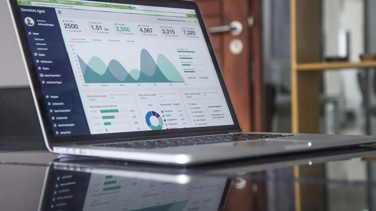 A financial analyst reviewing audit data and reports on a computer with charts and financial data visible on screen