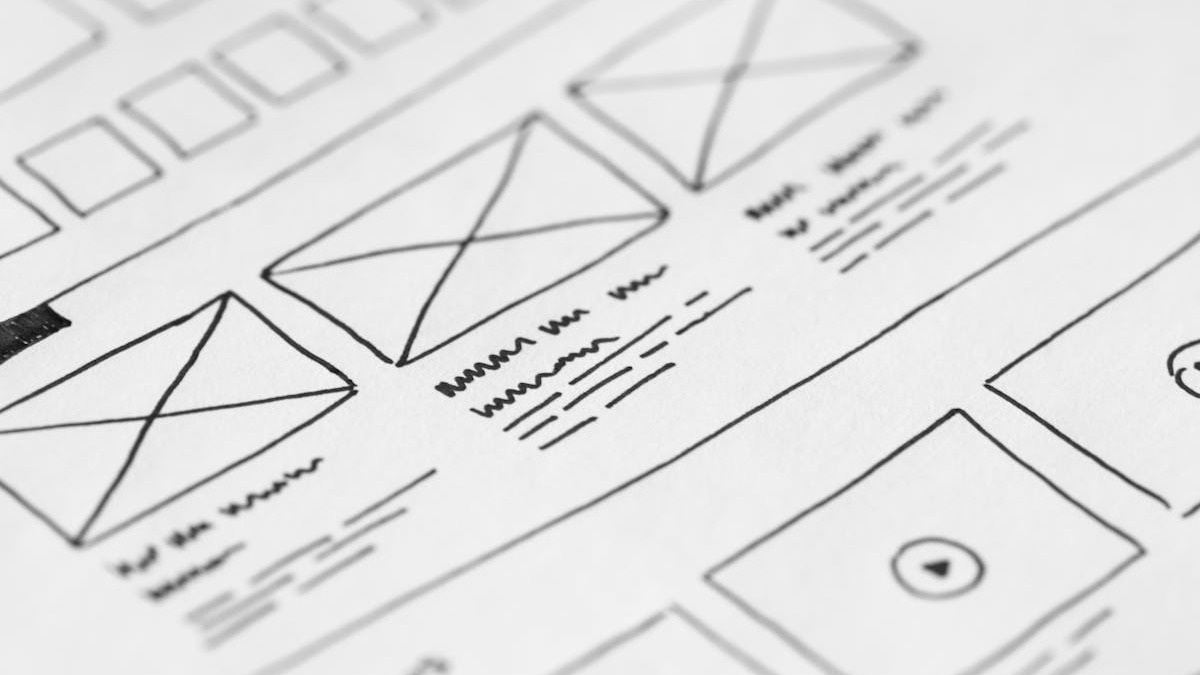 Designer working on UI mockups with Figma on a large monitor