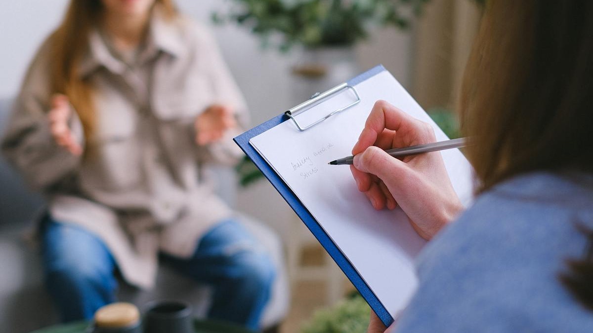 A psychologist writing notes during a psychotherapy session
