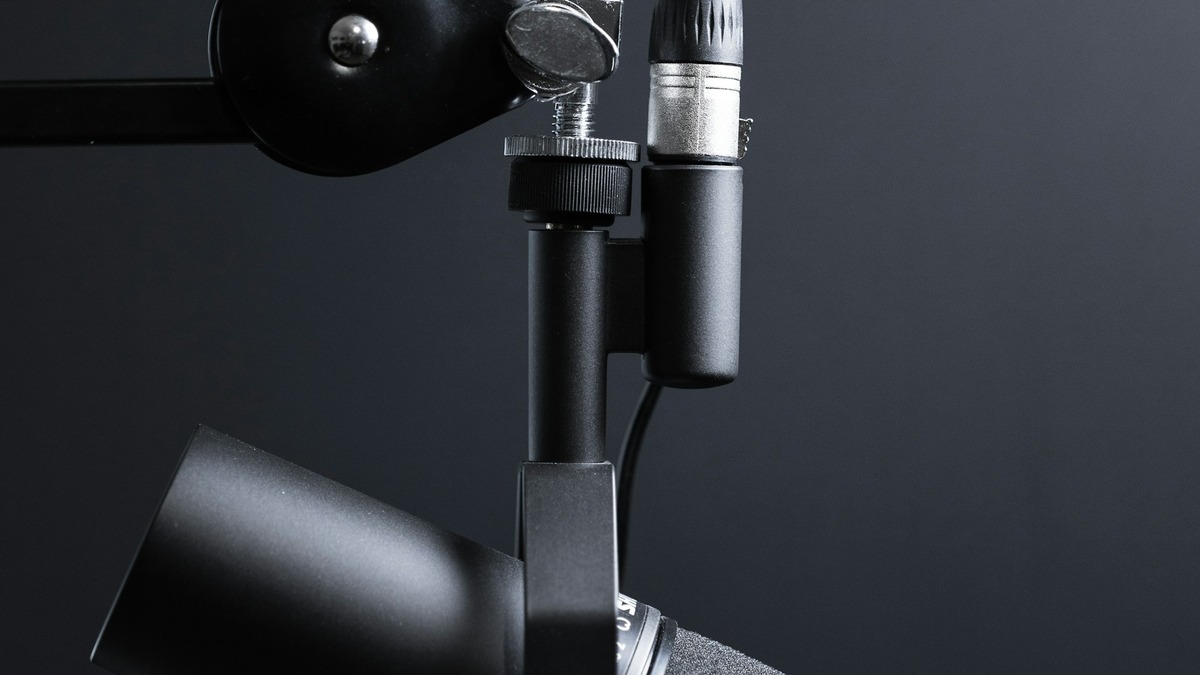 Person recording at a podcast desk with microphone and audio interface