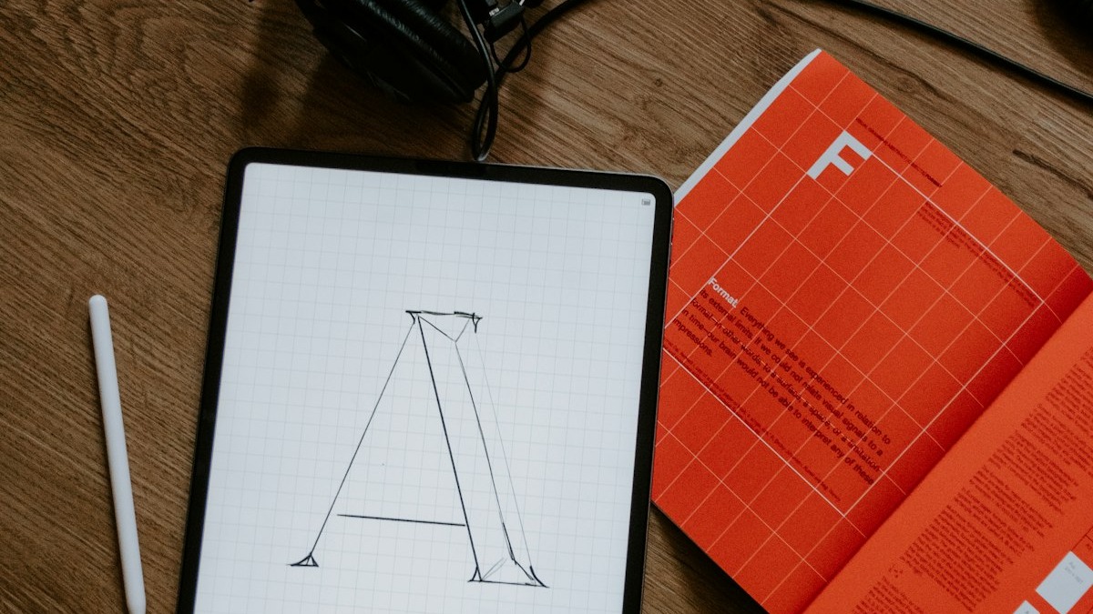 Artist working on digital illustrations at a desk with a drawing tablet