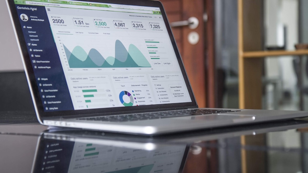 Laptop screen showing web analytics charts with traffic graphs and keyword rankings in a browser