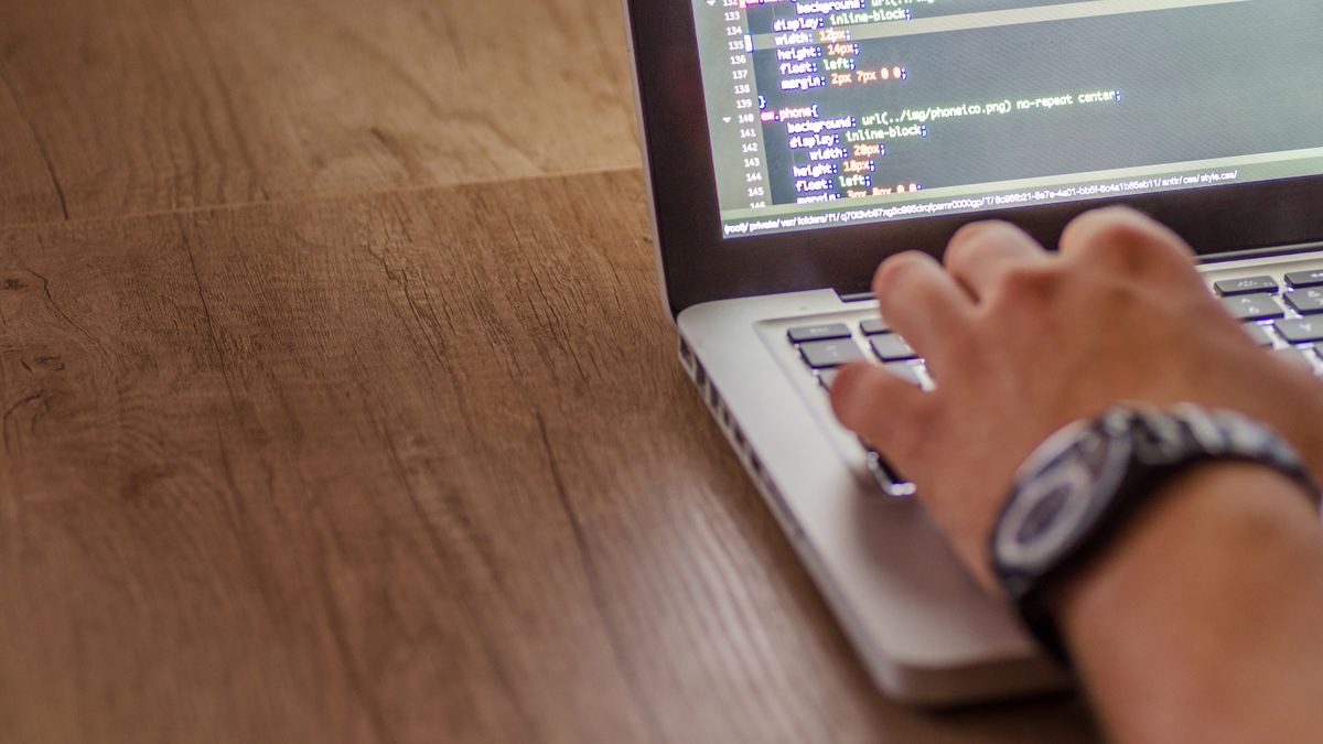 A developer reviewing code on a laptop - software engineering benchmarks like SWE-bench test real-world issue resolution